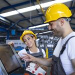 factory-worker-explaining-trainee-how-operate-industrial-machine-using-new-software-touch-screen-computer-Custom.jpg