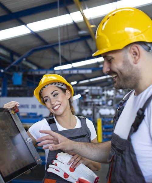 factory-worker-explaining-trainee-how-operate-industrial-machine-using-new-software-touch-screen-computer-Custom.jpg